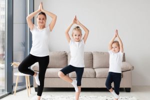 The mother and her children do the balancing exercise.
