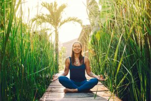 The woman meditates outside their home.
